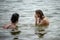 Two girls friends swim in the lake