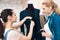 Two girls at garment factory desining new man suit jacket.