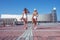 Two girls girlfriends, sisters white body bathing suit, summer city with board, skate longboard. Long hair tanned figure