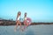 Two girls girlfriends, walk sand with inflatable circle, beautiful women summer beach white bodysuit. Rest by sea ocean