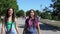 Two girls girlfriends are walking in the park having a good mood. slow motion