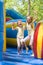 Two girls grimacing happily jumping on inflatable trampoline