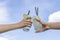 Two girls holding mojito cocktail in the hand against the blue sky. Freshness cocktail, closeup