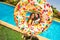Two girls with inflatable doughnut near pool
