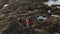 Two girls in Ireland climb over the rocky oceanfront of Malin Head