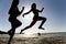 Two girls jumping on the beach