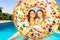 Two girls laughing inside inflatable doughnut