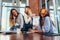 Two girls laughing at their friend with a sticky note on her face. Group of female students relaxing having fun in