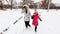 Two girls, mother and daughter, walking park in winter frosty day.