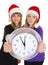 Two girls in New Year\'s caps with clock