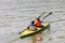 Two girls with oars are rowing synchronously on a kayak on the river. Amateur rafting