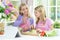 Two girls in pink aprons preparing salad