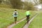 Two girls play sports in sunny morning`s weather. Cycling and walking under rain drops in sunny weather. Sport and healthy lifesty