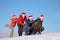 Two girls push two men on sled