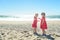 Two girls in red dress on the beach