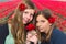 Two girls with red roses in front of tulip field