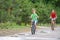 Two girls ride a bike on a rainy warm day