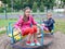 Two girls ride a carousel. Playground