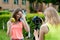 Two girls schoolgirl girlfriends. Summer in nature. The concept of healthy eating. Hand holds bottle water and green