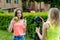 Two girls schoolgirl girlfriends. Summer nature. The concept healthy eating. Hand holds bottle of water green apple