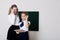 Two girls schoolgirl in glasses at the blackboard on the lesson at school