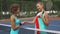 Two girls shaking hands before playing tennis