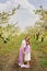 two girls sisters have fun and cuddle in the garden with flowering trees.