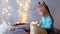 Two girls sisters jumping playing on bed in Christmas interior with garlands.