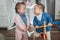 Two girls sisters playing on wooden rocking horse. Childhood, game at home