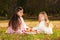 Two girls sisters read the book on the grass