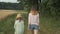 Two girls sisters walking together on country road, children talk enjoy nature background