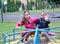 Two girls are sitting on a carousel. Playground