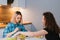 Two girls are sitting at the kitchen table and eating a diet salad. Girlfriends chatting over food