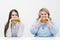 Two girls, slim and fat, blonde and brunette, eat hamburgers. On a white background, the theme of diet and proper
