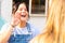 Two girls speaking in sign language in a public space. Deaf friends or couple communicating, having fun, pleasant conversation,