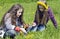 Two girls spin garland from yellow dandelions