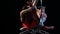 Two girls spinning on a hoop on stage. Black background. Slow motion. Close up