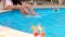 Two girls splashing around in a swimming pool.