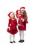 Two girls stand in a red dress in Santa Claus hats