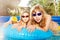 Two girls swimming in the pool with  rubber ring