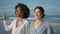 Two girls talking sea shore closeup. Carefree lesbian couple walking ocean coast