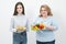 Two girls, thick and thin, with healthy food from vegetables and fruits and unhealthy fast food with a hamburger. The