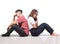 Two girls and tomboy friends sitting think on floor with white background