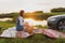 two girls are traveling on the roads by car and stopped for a roadside picnic