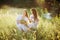 Two girls in Ukrainian national dress sitting on the grass. Girl