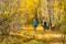 Two girls, view from the back, walk through the deciduous forest