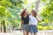 Two girls walking embraced at park.