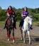 Two girls walking on horseback