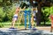 Two girls warm up on exercise machines in the park