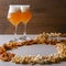 Two glass of beer and beer snacks over white background. Potato chips and popcorn shaped like an 8